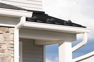 An image of white gutters on the edge of a residential roof